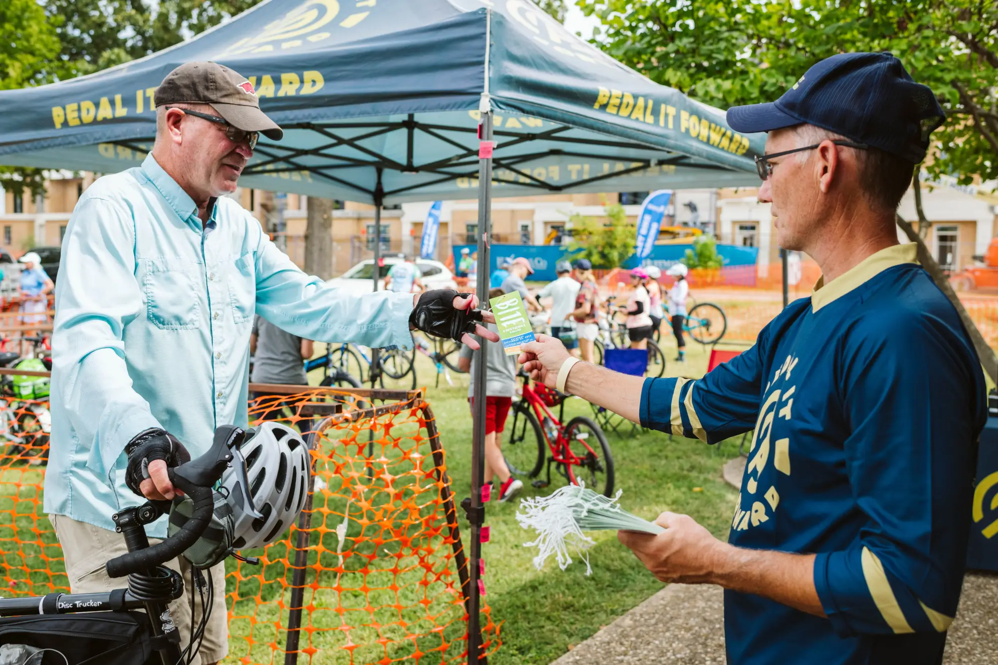 Pedal it Forward tent man giving ticket away