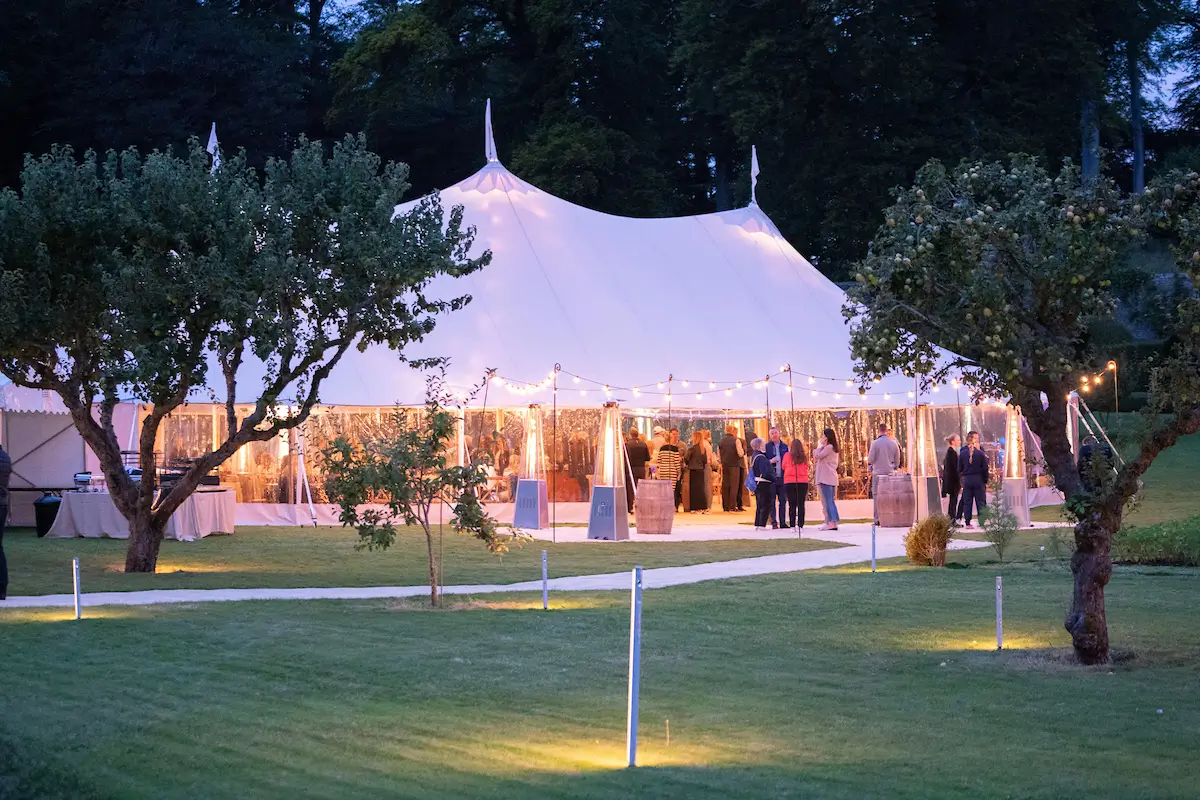 Evening reception tent with people and green grass