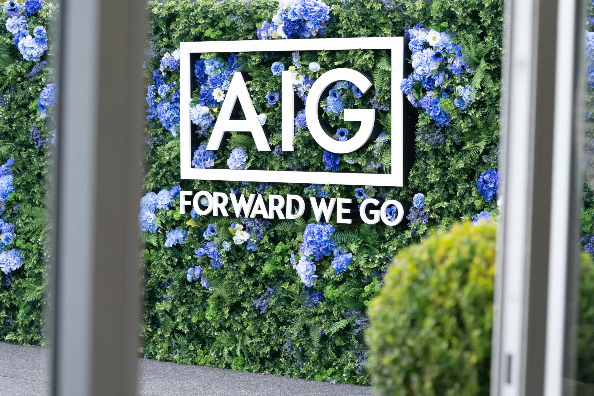 AIG logo sign on greenery